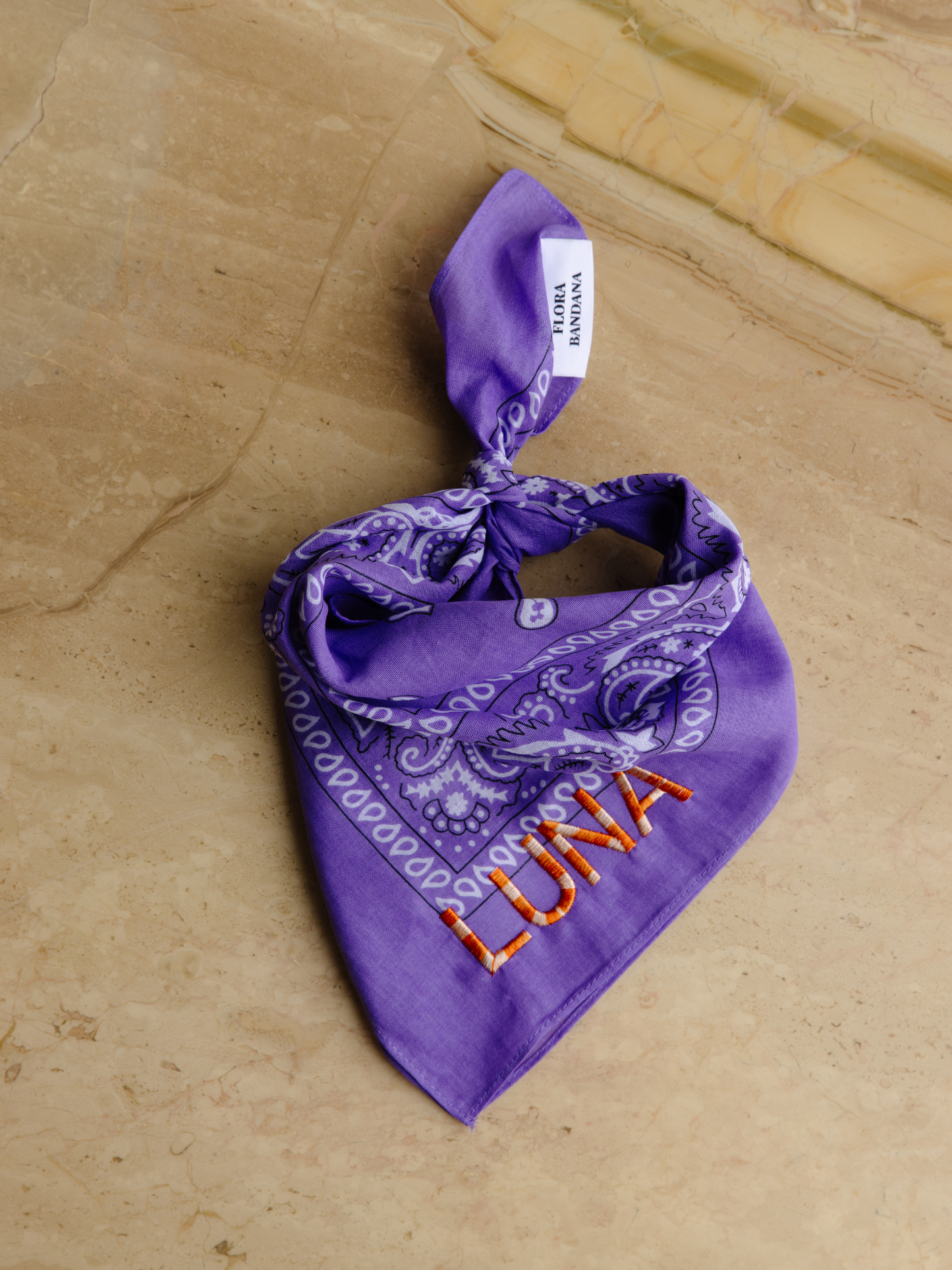 Lilac bandana with ombré orange yarn and a personalized name